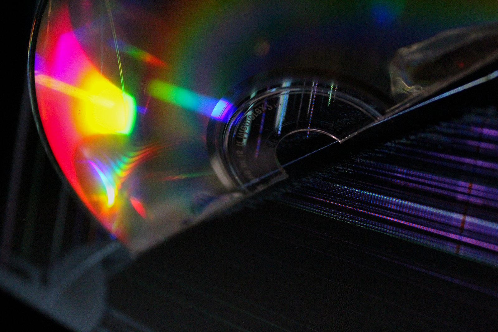 Disc catching full-spectrum prism light on dark ground