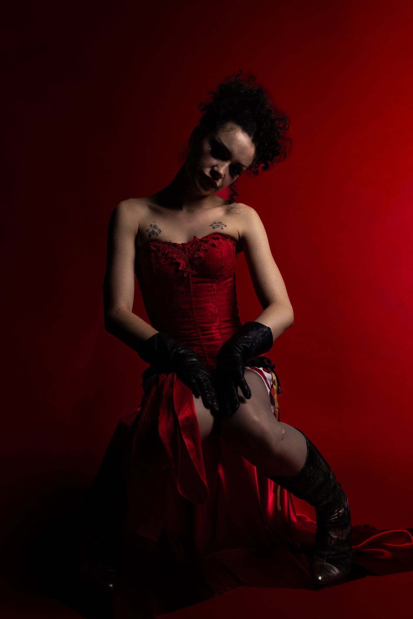 Black leather gloves over red corset