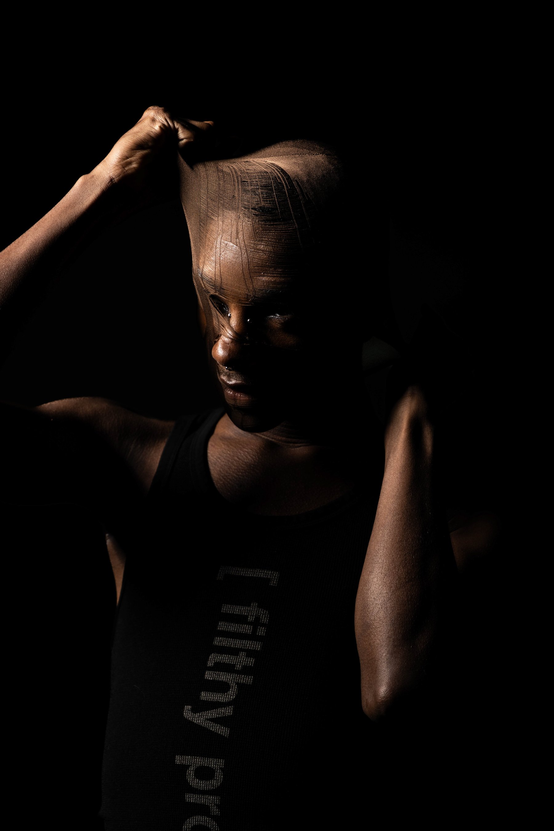 Portrait with sheer fabric pulled across the face